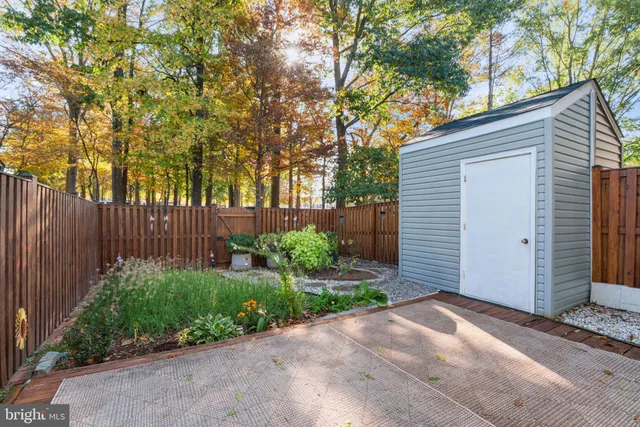 a view of backyard with potted plants and wooden fence