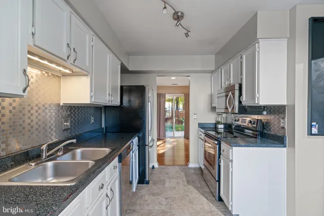 a kitchen with a sink stove top oven and refrigerator