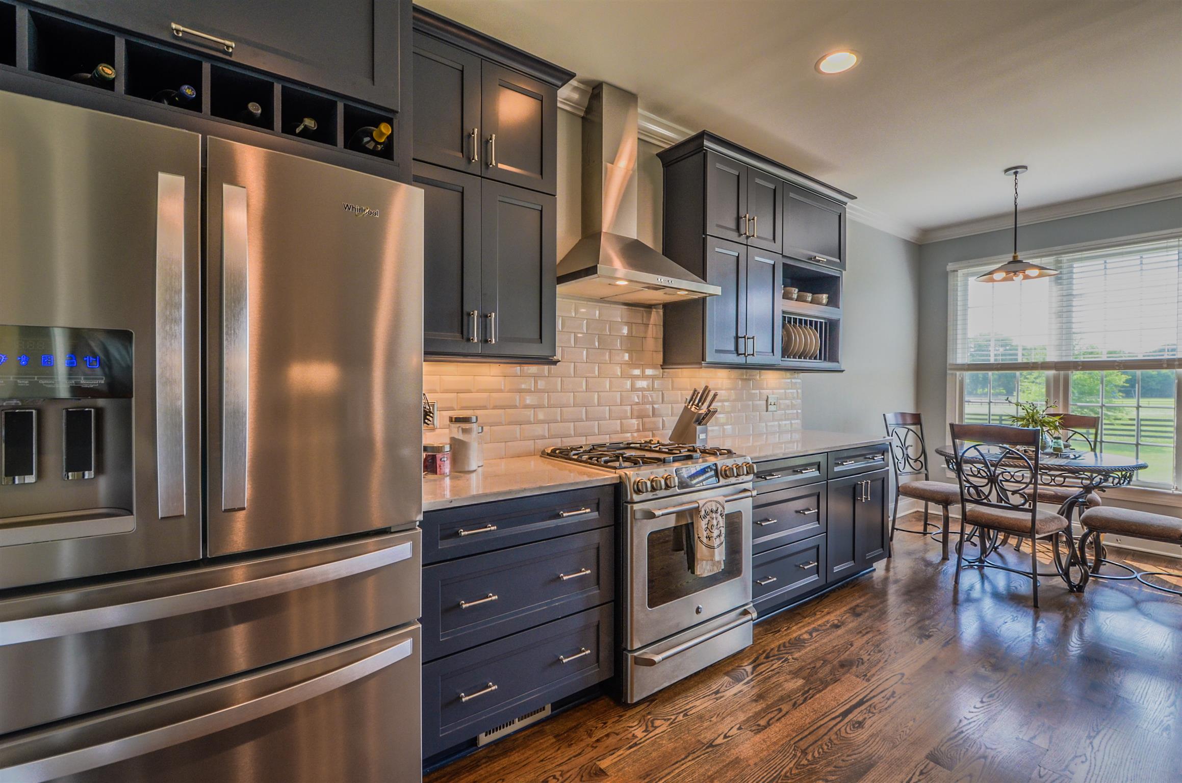 4097 Trinity Road Franklin, TN 37067 - Photo 16 of 30 a kitchen with stainless steel appliances granite countertop a refrigerator a stove a sink a dining table and chairs with wooden floor
