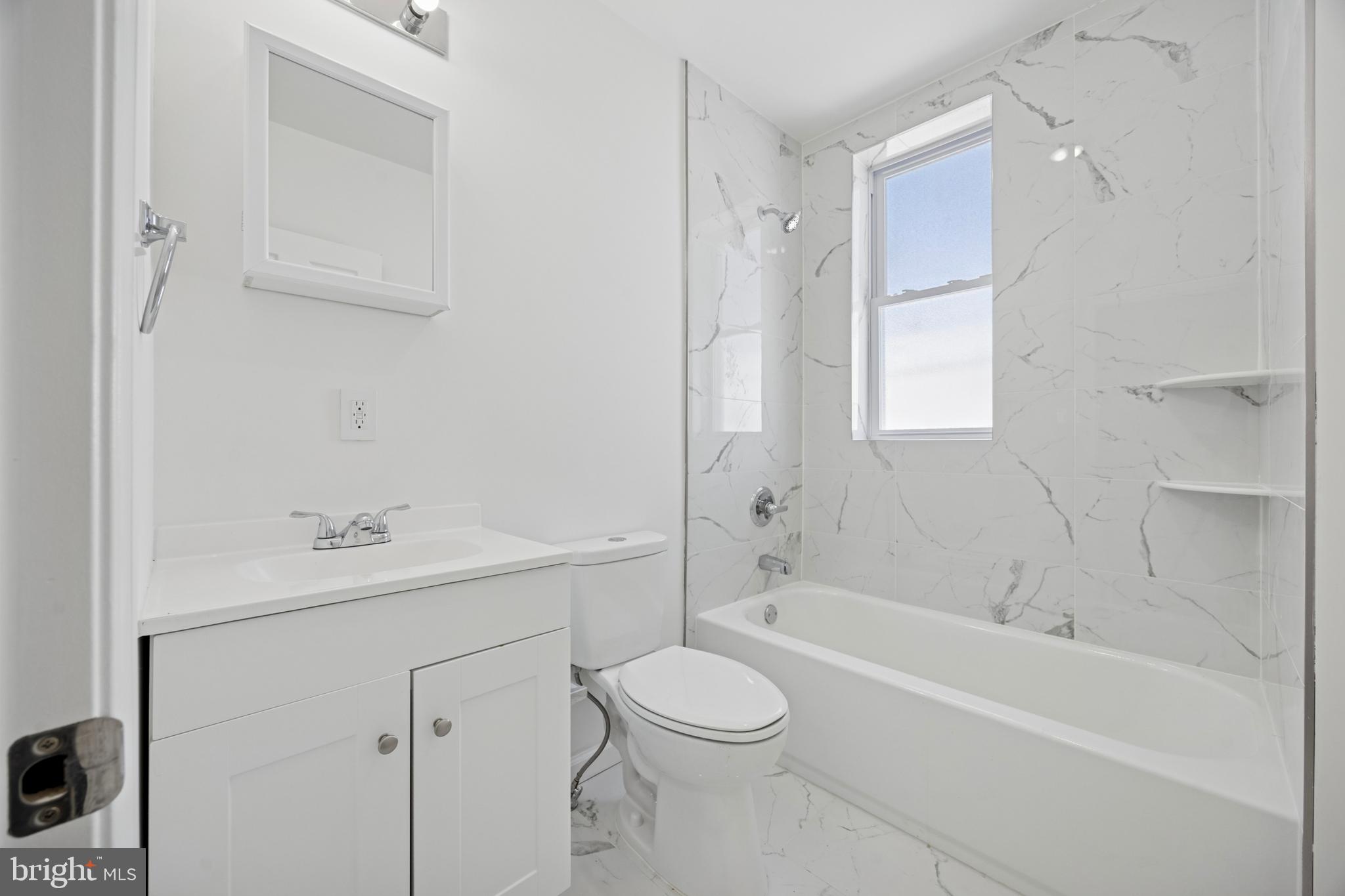 278 South 60th Street Philadelphia, PA 19139 - Photo 13 of 20 a bathroom with a toilet a sink a mirror a bathtub and vanity