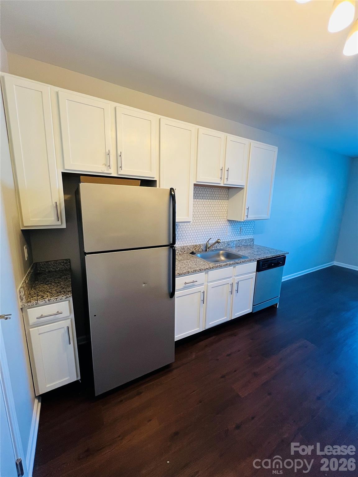 4310 Park Road, Unit 207 Charlotte, NC 28209 - Photo 4 of 9 a kitchen with stainless steel appliances granite countertop a refrigerator sink and white cabinets