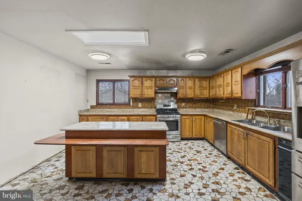 a kitchen with stainless steel appliances granite countertop a sink and cabinets