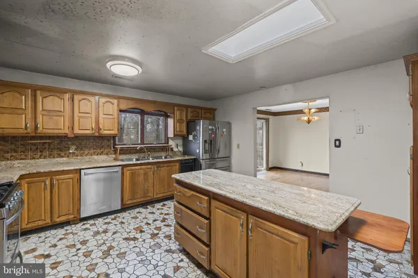 a kitchen with stainless steel appliances granite countertop a refrigerator stove and sink