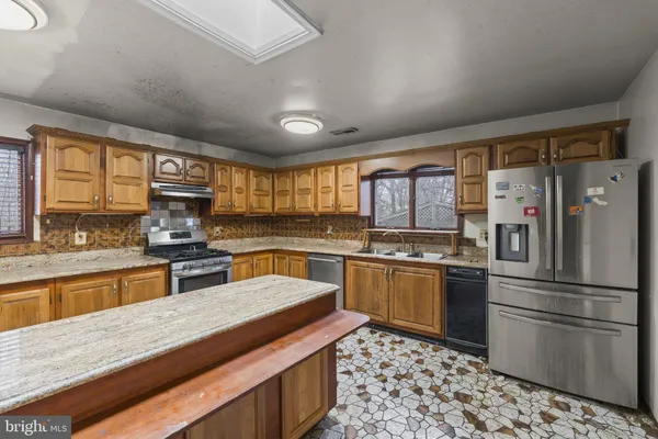 an empty room with wooden floor ceiling fan and windows