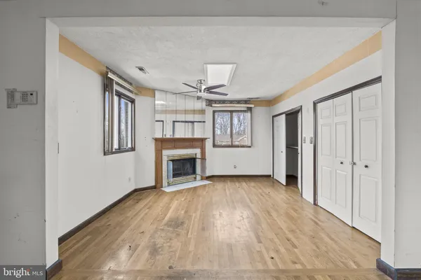 a view of an empty room with a fireplace and a window