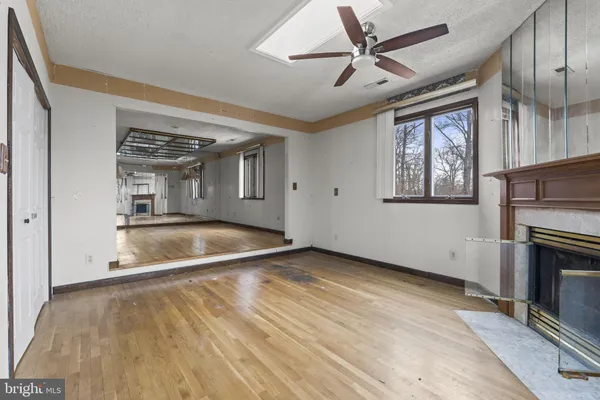 an empty room with windows and fireplace