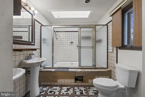 a bathroom with a granite countertop sink a toilet and a mirror