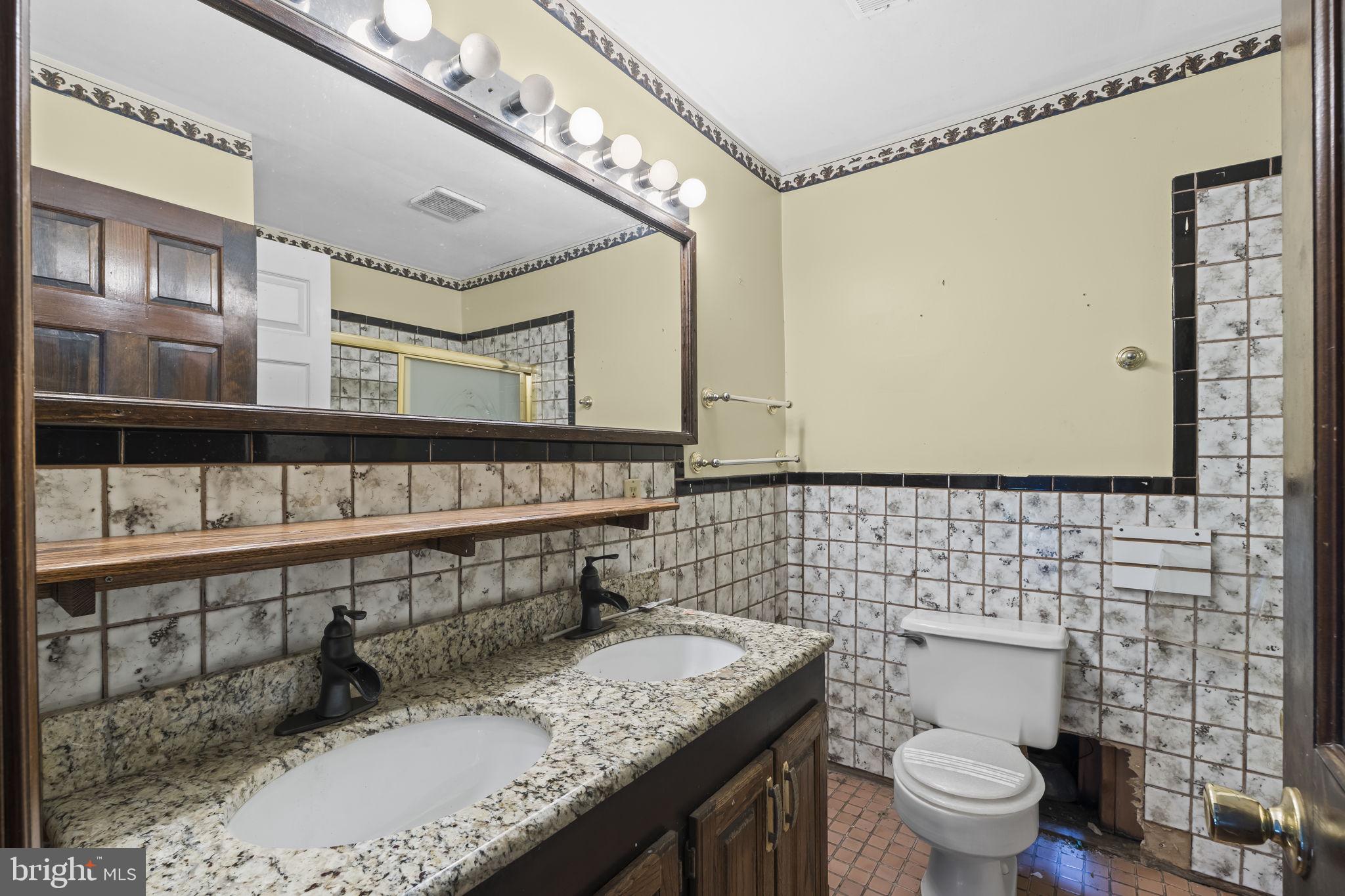 7811 Heflin Drive Clinton, MD 20735 - Photo 32 of 55 a bathroom with a granite countertop sink a toilet and a mirror