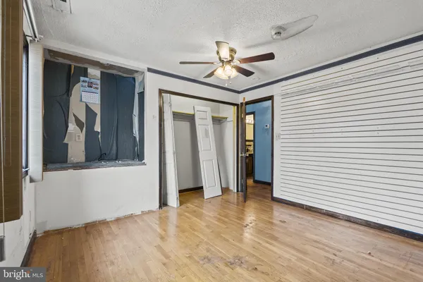 a view of an empty room with wooden floor and a fireplace