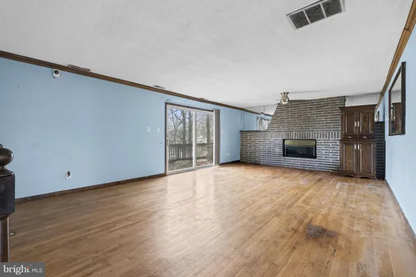 a view of empty room with wooden floor and fireplace