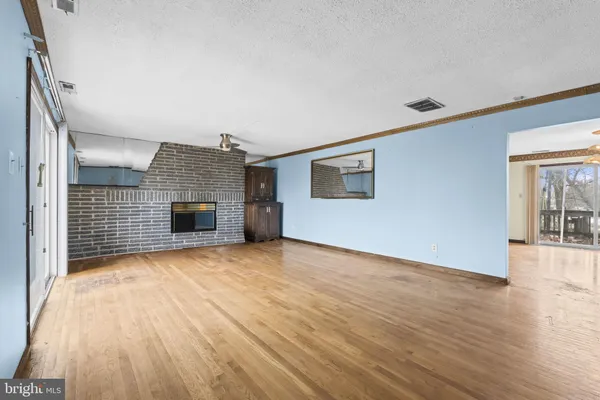 a view of empty room with wooden floor and fireplace