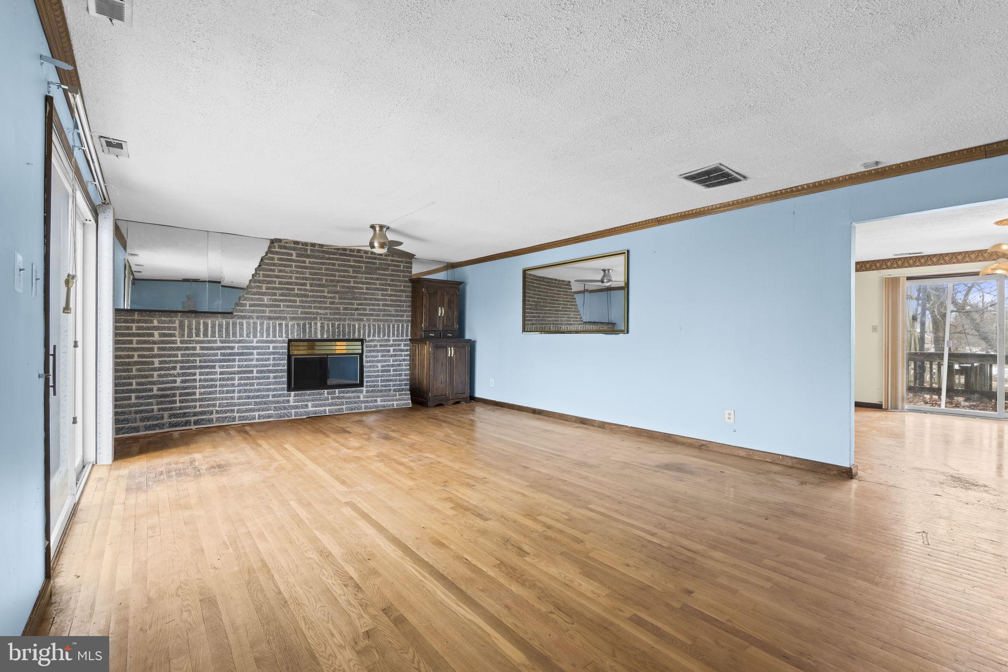 7811 Heflin Drive Clinton, MD 20735 - Photo 10 of 55 a view of empty room with wooden floor and fireplace