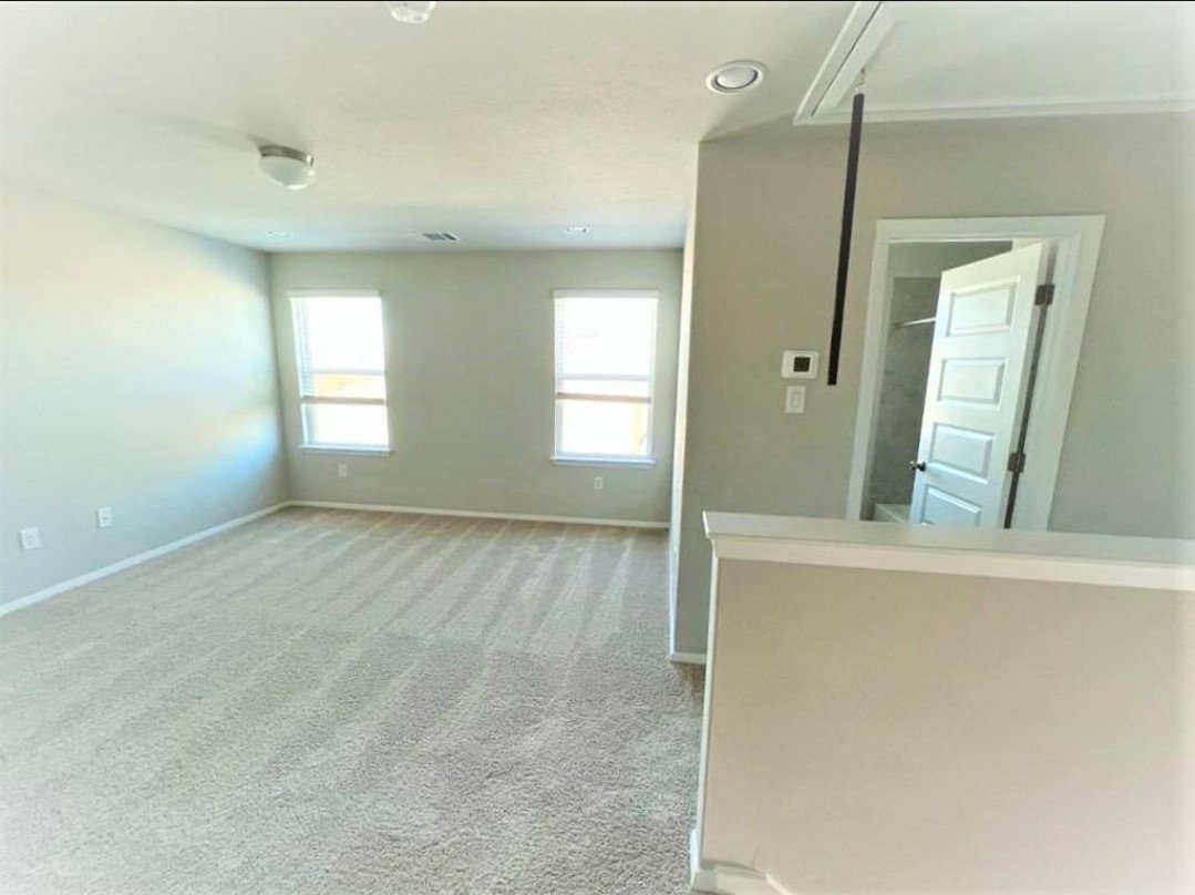 2771 Winding Creek Road Kyle, TX 78640 - Photo 13 of 24 A well-lit, open-concept bonus room with plush carpeting and natural illumination from multiple windows.
