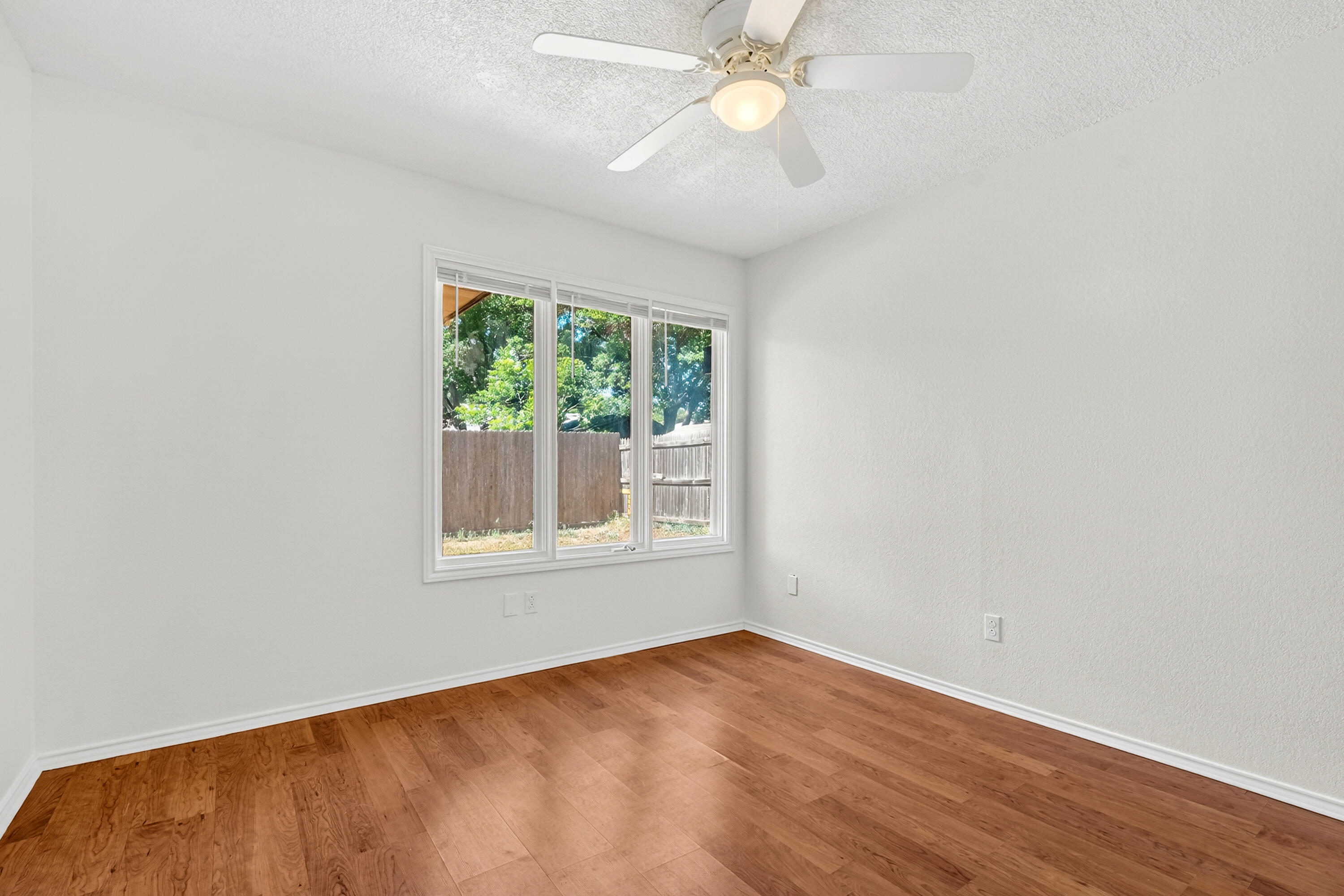 5221 84th Street Lubbock, TX 79424 - Photo 19 of 26 an empty room with a window and wooden floor
