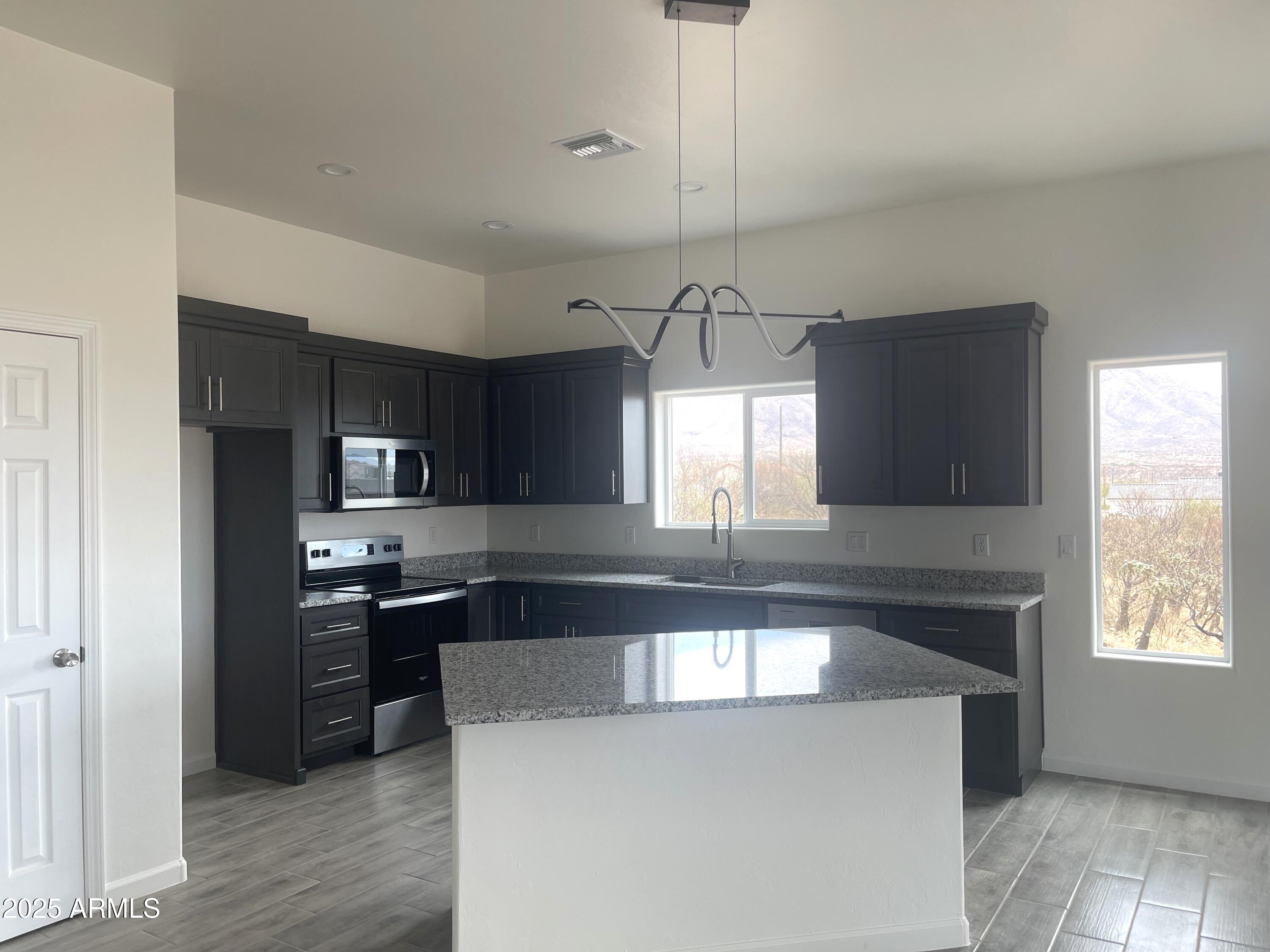 1798 Birmania Corte Rio Rico, AZ 85648 - Photo 12 of 27 a large kitchen with stainless steel appliances granite countertop a stove a sink and a refrigerator