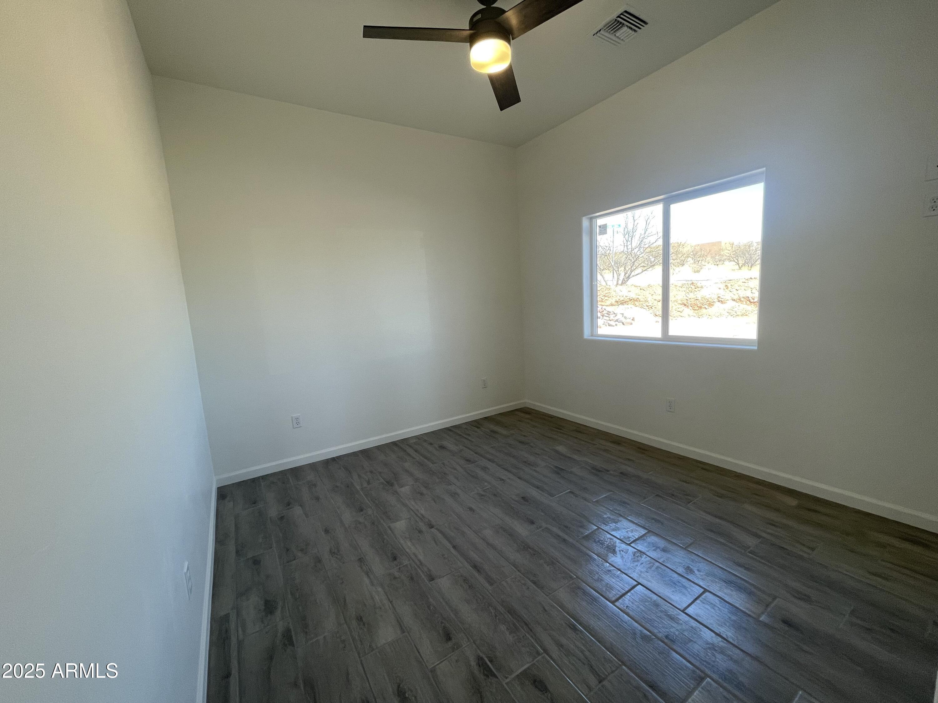 1798 Birmania Corte Rio Rico, AZ 85648 - Photo 16 of 27 an empty room with wooden floor and windows