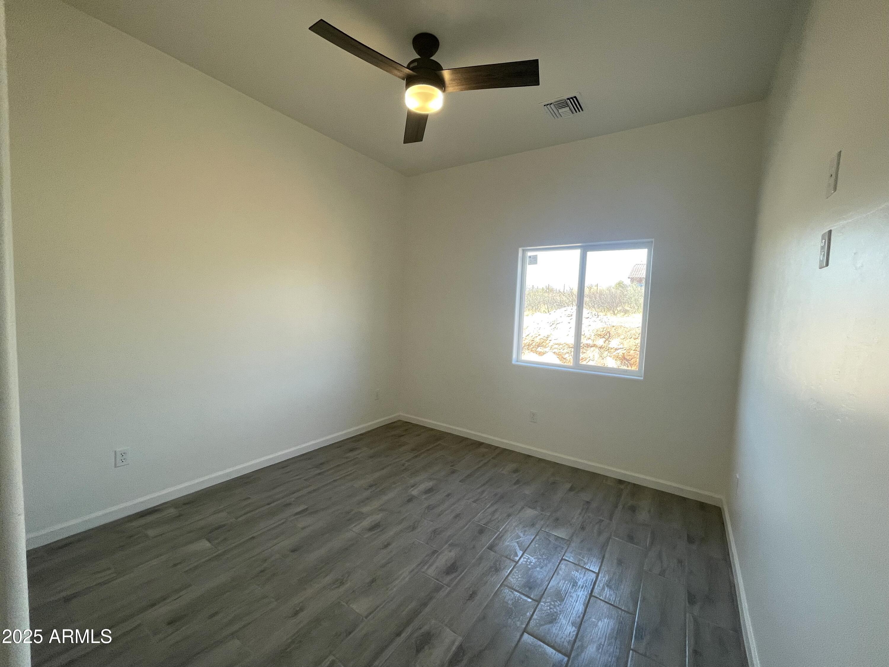 1798 Birmania Corte Rio Rico, AZ 85648 - Photo 18 of 27 an empty room with wooden floor ceiling fan and windows