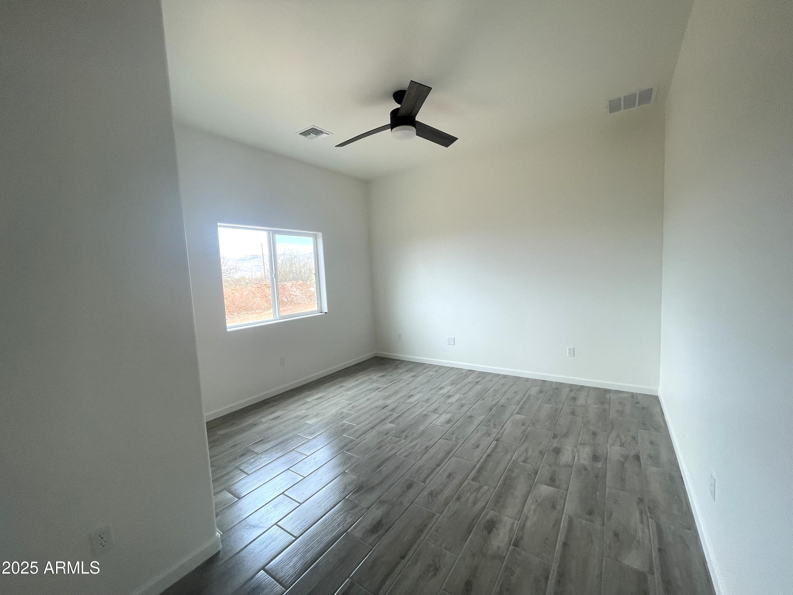 1798 Birmania Corte Rio Rico, AZ 85648 - Photo 19 of 27 an empty room with wooden floor chandelier fan and windows