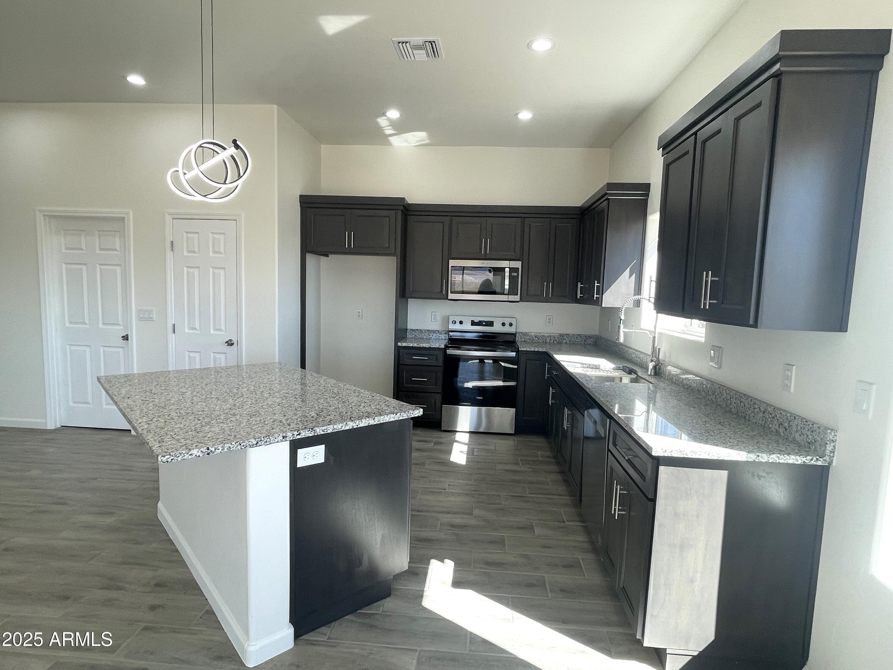 1798 Birmania Corte Rio Rico, AZ 85648 - Photo 7 of 27 a large kitchen with stainless steel appliances granite countertop a stove a sink and a refrigerator