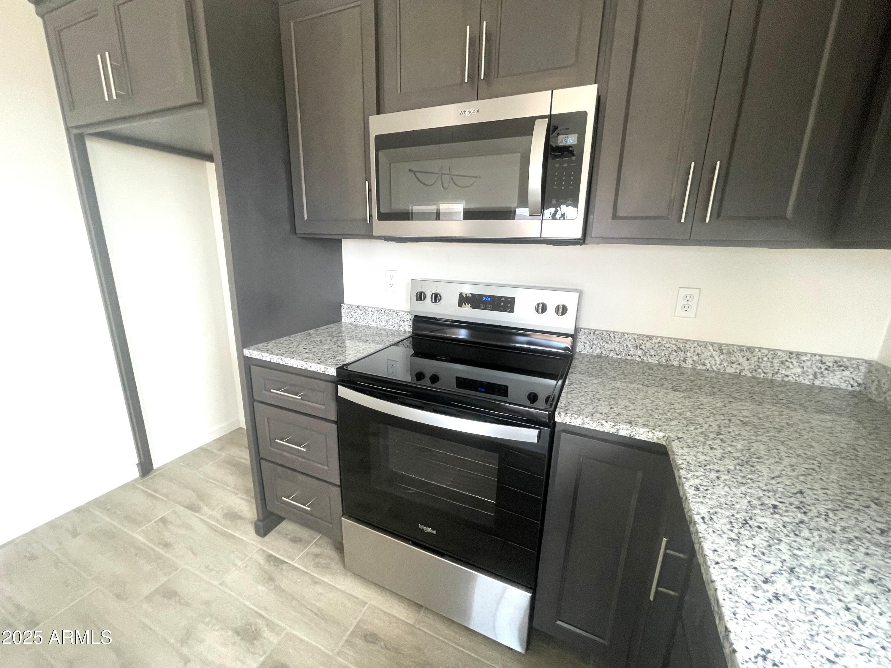 1798 Birmania Corte Rio Rico, AZ 85648 - Photo 10 of 27 a kitchen with granite countertop a stove and a microwave