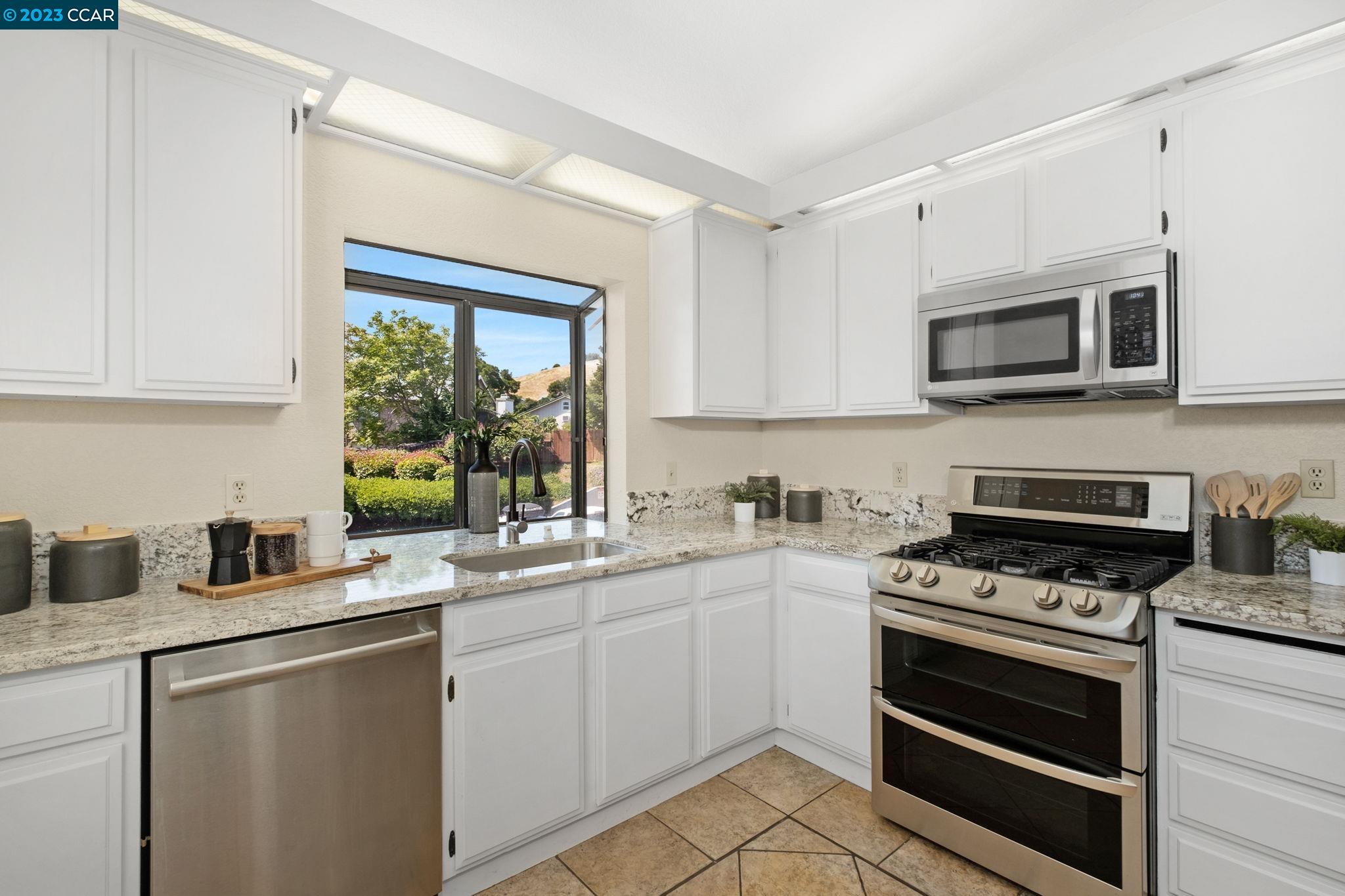 570 Bustos Place Bay Point, CA 94565 - Photo 14 of 26 a kitchen with stainless steel appliances a stove sink microwave and cabinets