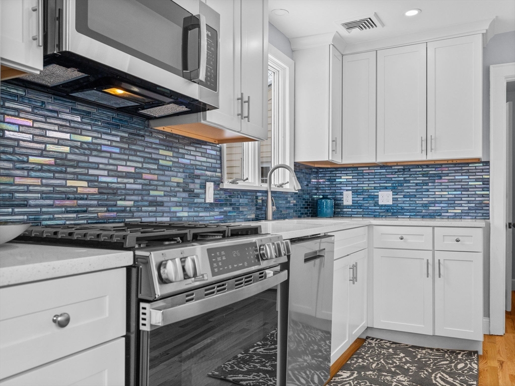 7 Neillian Crescent Boston, MA 02130 - Photo 7 of 29 a kitchen with stainless steel appliances granite countertop a stove a sink and white cabinets