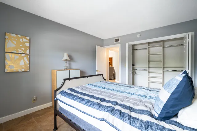 a bedroom with a bed and a dresser next to a window