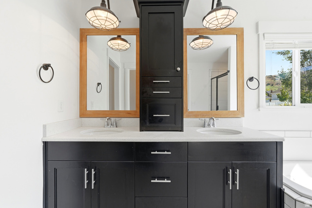338 Windy Rdg Drive Smithfield, UT 84335 - Photo 33 of 63 Double vanity featuring black cabinetry, light-toned countertops, dual undermount sinks, and two wooden-framed mirrors