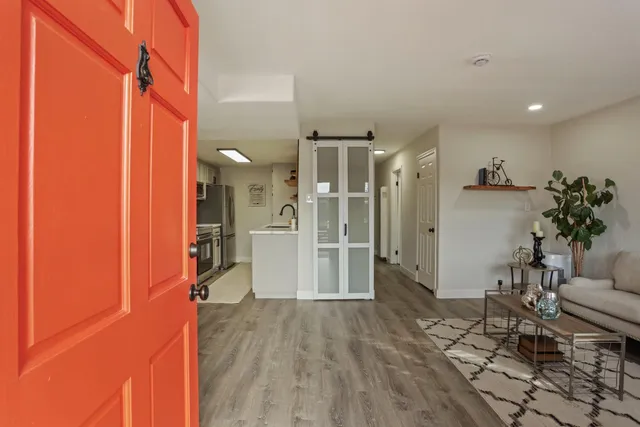 a view of a hallway with wooden floor and a living room