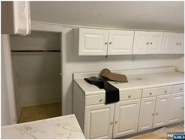 a kitchen with a refrigerator and white cabinets