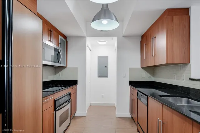 a kitchen with stainless steel appliances granite countertop a sink and a stove