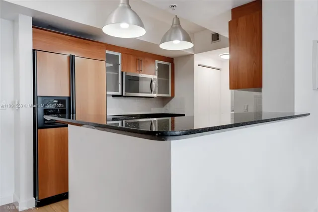 a kitchen with stainless steel appliances a refrigerator sink and microwave