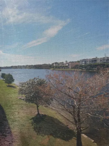 a view of a lake with beach and mountain in the back