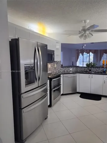 a kitchen with stainless steel appliances granite countertop a refrigerator and a stove top oven