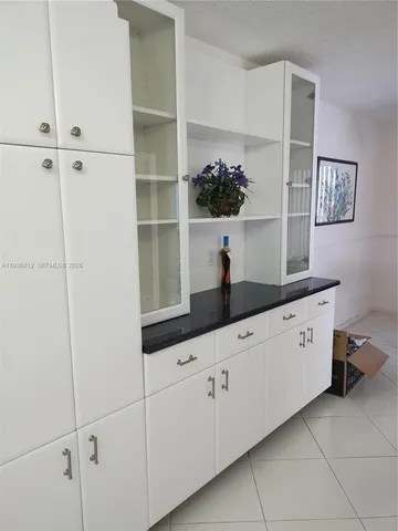 a hallway with white cabinets and white appliances