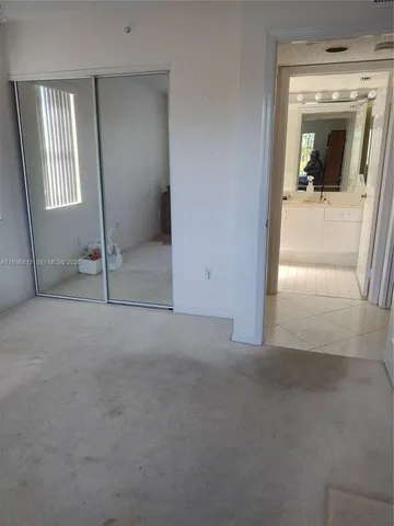 an empty room with mirror and windows