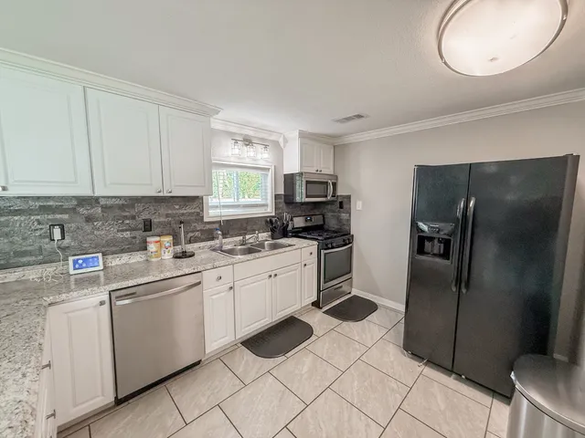 a kitchen with a refrigerator sink and cabinets