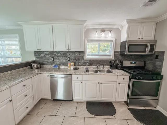 a kitchen with stainless steel appliances granite countertop a sink and cabinets