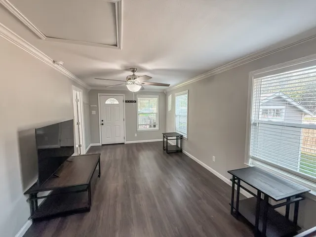 a view of a room with wooden floor and furniture
