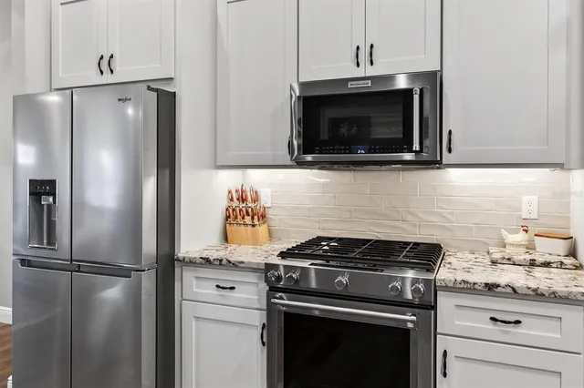 a en suite bathroom with a granite countertop double vanity and mirror