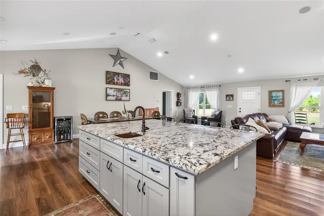 a kitchen with cabinets stainless steel appliances and wooden floor