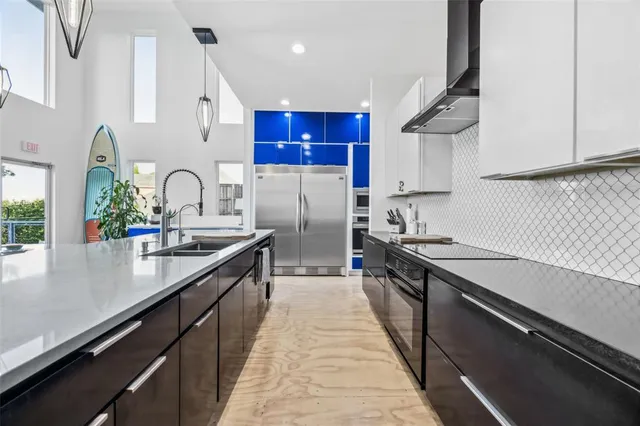a kitchen with stainless steel appliances granite countertop a sink a stove and a refrigerator