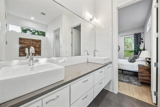 a spacious bathroom with double sink and a large mirror