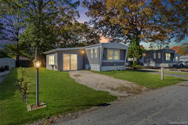 a front view of a house with a yard and trees