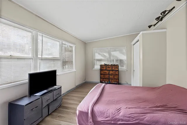 a bed sitting in a bedroom next to a window with a flat screen tv