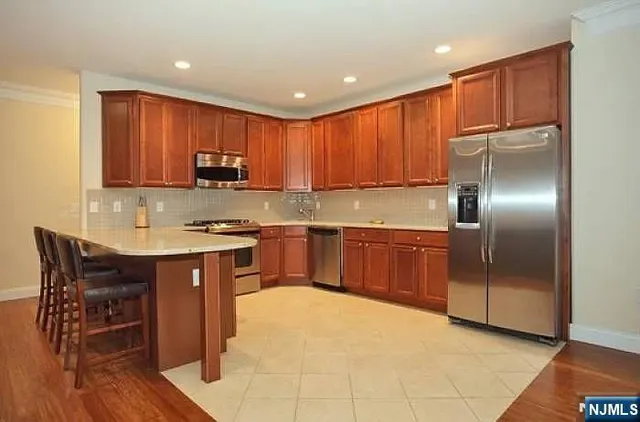 a kitchen with kitchen island granite countertop wooden cabinets a sink and a stainless steel appliances