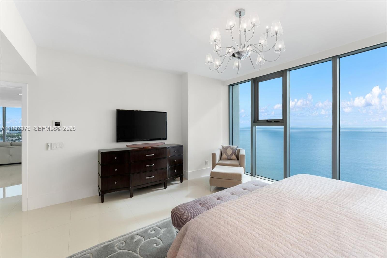 6899 Collins Avenue, Unit LPH04 Miami Beach, FL 33141 - Photo 14 of 29 a bedroom with a bed and a flat screen tv