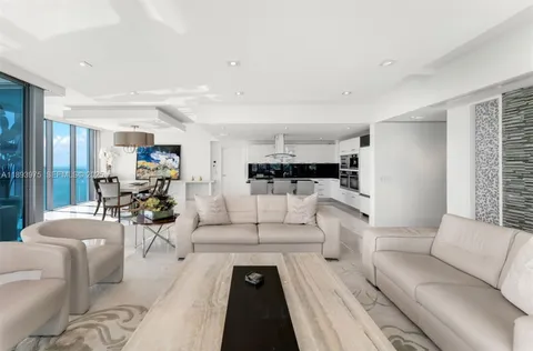 a living room with furniture a chandelier and a flat screen tv
