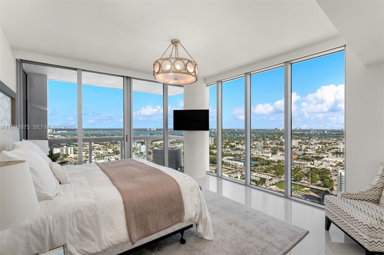 6899 Collins Avenue, Unit LPH04 Miami Beach, FL 33141 - Photo 22 of 29 a spacious bedroom with a large bed and a tv