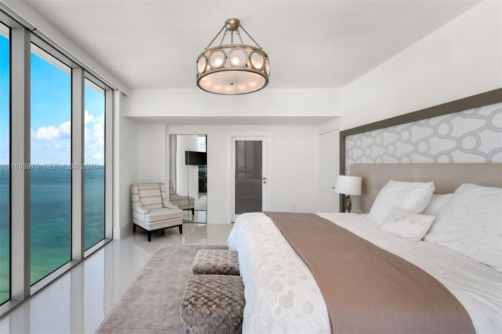 6899 Collins Avenue, Unit LPH04 Miami Beach, FL 33141 - Photo 23 of 29 a bedroom with a bed and wooden floor